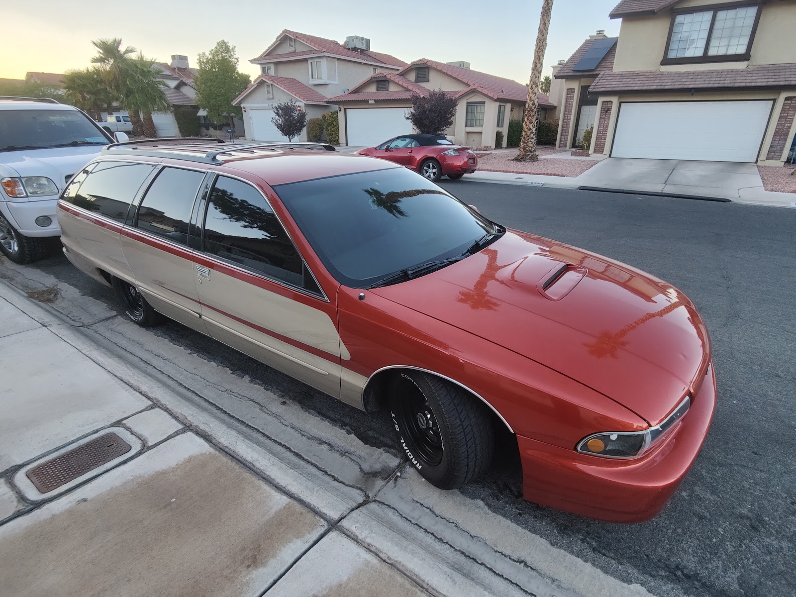 Orange Chevrolet Caprice wagon with tinted windows at dusk