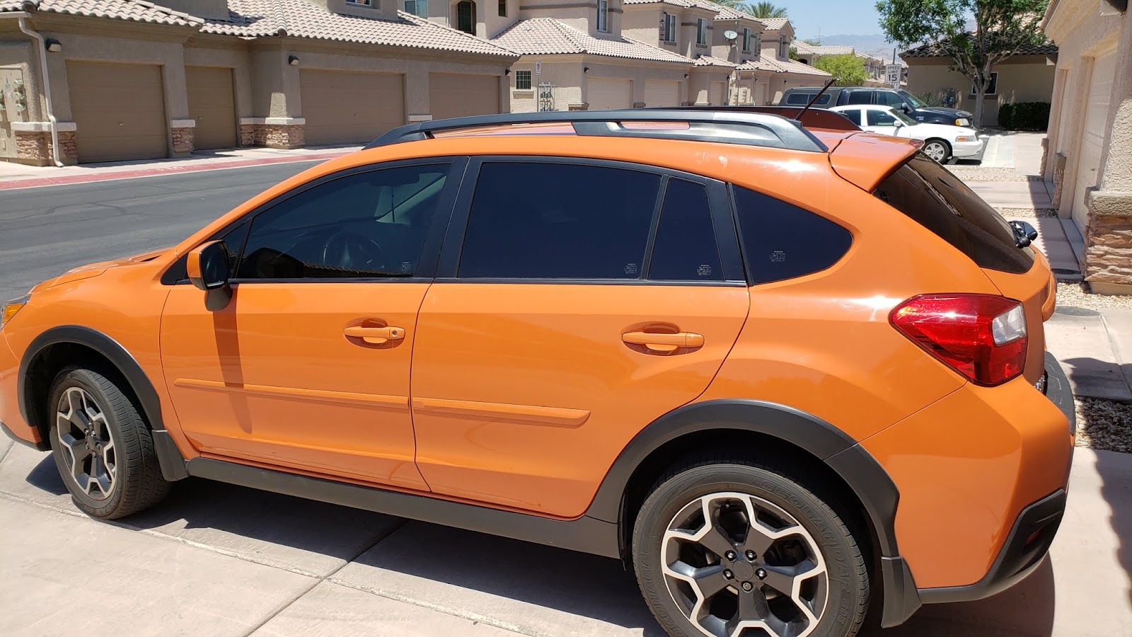 Orange Subaru Crosstrek with tinted windows parked on a driveway